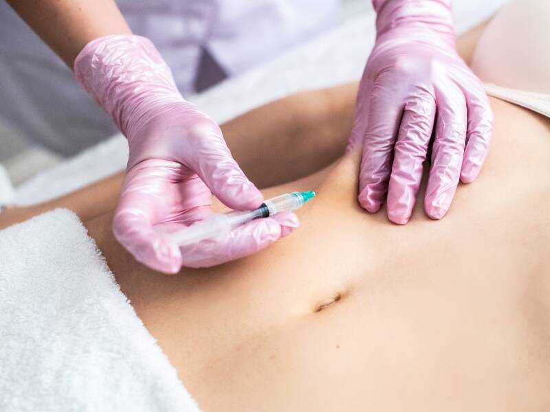 Aplicação de injeção no abdômen por profissional de saúde